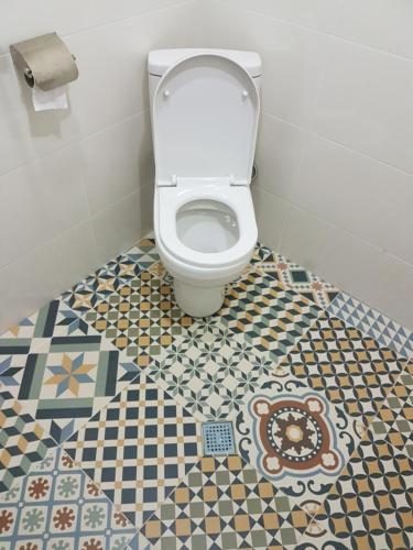 une salle de bain avec WC avec un sol en mosaïque dans l'établissement Cosy Apartment, à Bordjomi