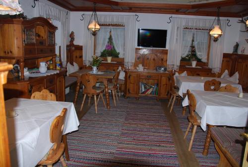 a dining room with tables and chairs and a television at Rosumerhof in Leutasch