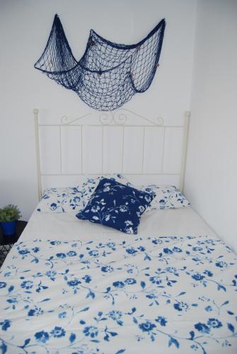 łóżko z niebiesko-białą kołdrą i siecią w obiekcie M3 904 Azul Mediterráneo bonito y confortable estudio w mieście Benalmádena