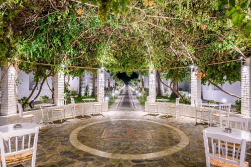 a wedding aisle with trees and white chairs at Solimar White Pearl - Adults Only in Kolymvari