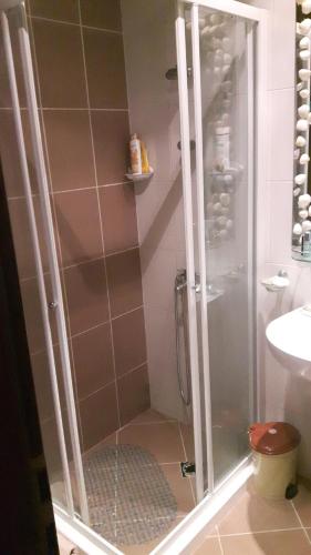 una doccia con porta in vetro in bagno di Hacienda Beach Apartment mit Meerblick a Sozopol