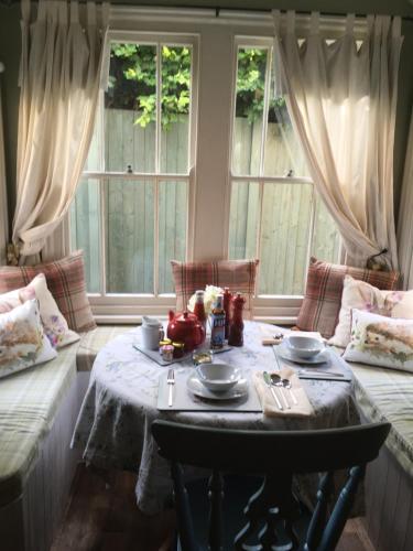 uma sala de estar com uma mesa e duas janelas em Lodbourne House B&B em Gillingham