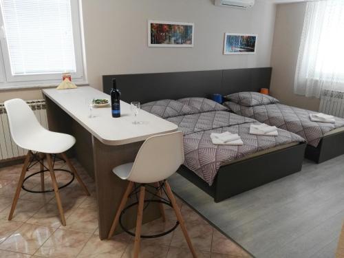 a bedroom with a bed and a table and two chairs at Apartmani Janjic in Banja Luka