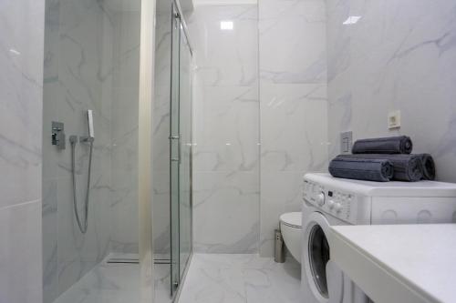ein weißes Bad mit einer Dusche und einem WC in der Unterkunft DELMAR Residence in Becici