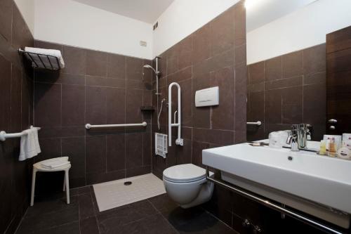 a bathroom with a toilet, sink, and bathtub at Hotel City Parma in Parma