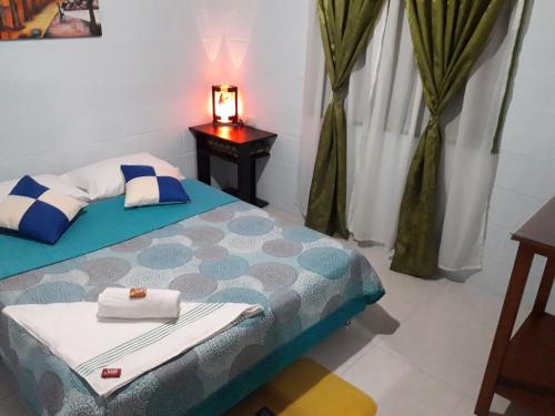 a bedroom with a bed and a table with a lamp at Vivienda Turistica Yerbabuena in Filandia