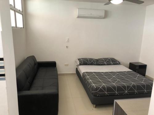 1 dormitorio pequeño con 1 cama y 1 sofá en EDIFICIO PALANOA APTO 507PQ RODADERO en Santa Marta