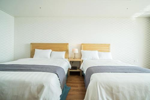 two beds sitting next to each other in a room at Breeze Bay Hotel in Seogwipo