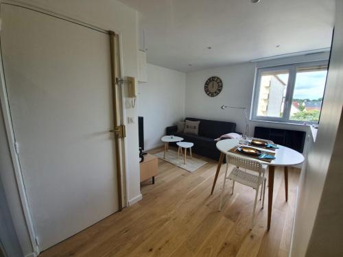 a living room with a table and a window at les lilas in Ozoir-la-Ferrière