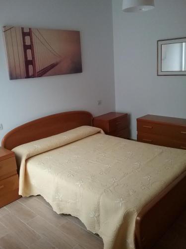 a bedroom with a bed and a painting on the wall at Ático vacacional in Muros