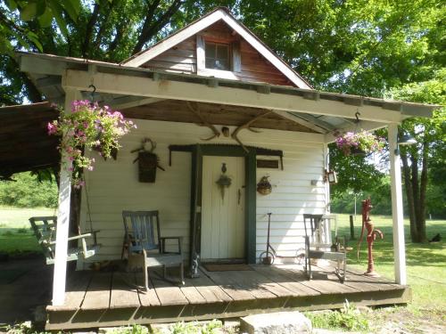 a small white house with a porch and chairs at Mulberry Lavender Farm and B&B in Mulberry