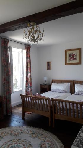1 Schlafzimmer mit 2 Betten und einem Fenster in der Unterkunft La Maison Bourgeoise in Saint-Priest-des-Champs