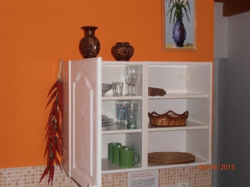 a white cabinet with plates and vases on it at Zelený Dom in Bojnice