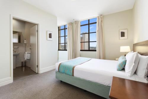 a bedroom with a large bed and a bathroom at Launceston Central Apartment Hotel Official in Launceston