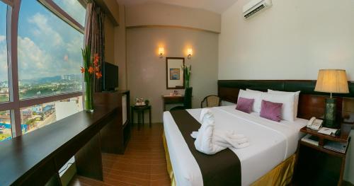 Una habitación de hotel con una cama con toallas blancas. en Allure Hotel & Suites, en Cebú