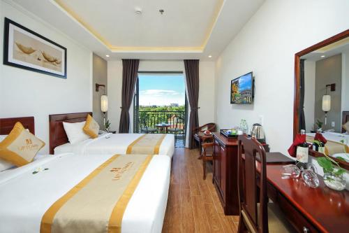 Säng eller sängar i ett rum på Uptown Hoi An Hotel & Spa