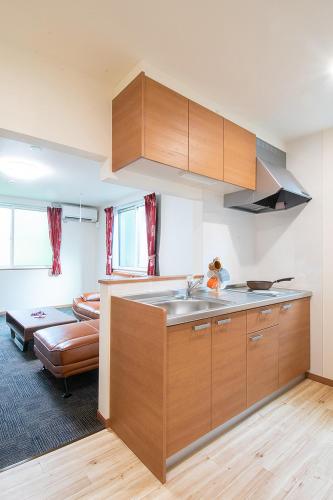 a kitchen with wooden cabinets and a sink at Stay Asahikawa Koto in Asahikawa