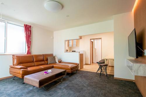 a living room with a couch and a table at Stay Asahikawa Koto in Asahikawa