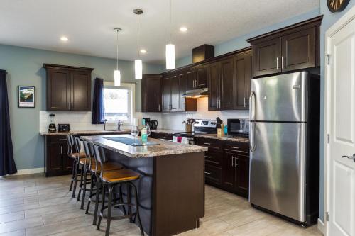 a kitchen with wooden cabinets and a stainless steel refrigerator at Mountain House in Edmonton