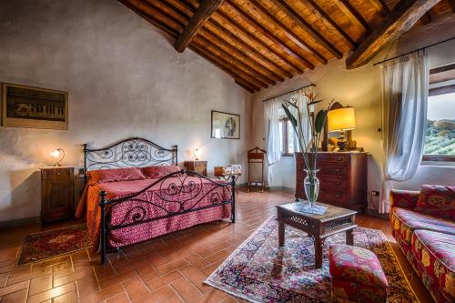 Villa Campestri Olive Oil Resort في فيتشو: غرفة نوم بسرير واريكة وطاولة