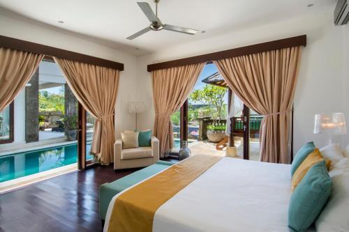 ein Schlafzimmer mit großem Bett und Pool in der Unterkunft Villa Amanie - Private Villa with Infinity pool, Stunning Views and Cook in Jimbaran