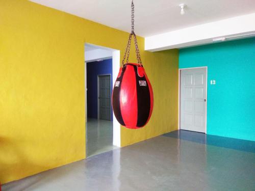a red swing hanging from a room with yellow walls at Sandakan Backpackers Hostel in Sandakan