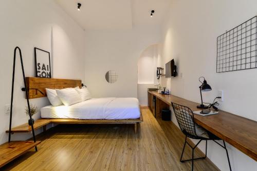 a bedroom with a bed and a desk at Leaf Signature Hotel - Lá Group in Ho Chi Minh City