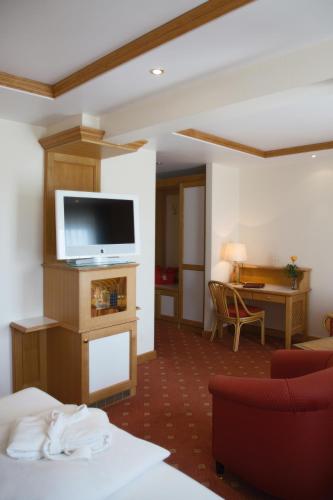 a hotel room with a bed and a television at Thermenhotel Quellenhof in Bad Füssing