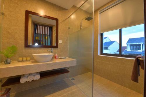 a bathroom with a sink and a glass shower at Saclo Villa and Hostel in Hoi An