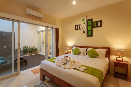 ein Schlafzimmer mit einem Bett mit zwei Schwänen darauf in der Unterkunft Villa Julie & Villa Sydney, Seminyak - 2 Bedroom Modern Pool Villas! in Seminyak