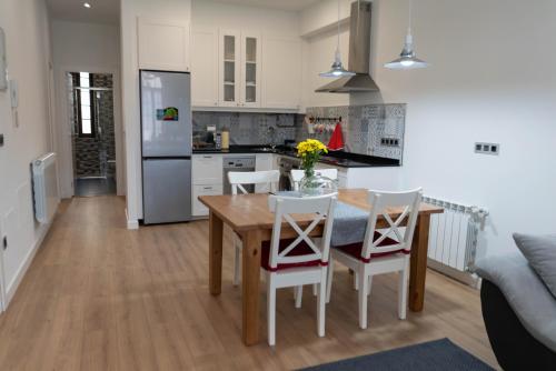 a kitchen and dining room with a wooden table and chairs at La Casa de Loli in Luarca