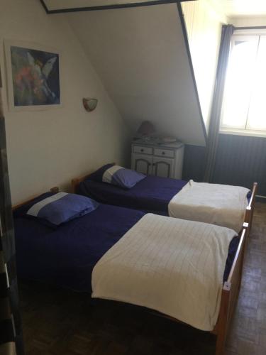 deux lits dans une petite pièce avec une fenêtre dans l'établissement La Mansardière, à Berck-sur-Mer