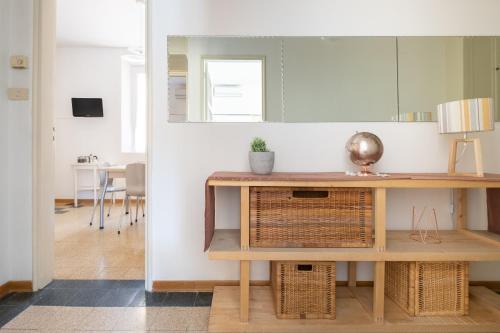 a living room with a table and a mirror at Residenza Ariosto by Studio Vita in Bologna