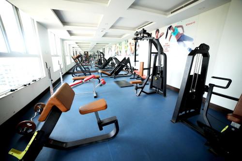 a gym with a row of treadmills and machines at Rg Royal Hotel in Bengaluru
