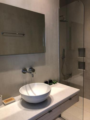 a bathroom with a bowl sink and a shower at Theros apartments 2 in Mylopotas