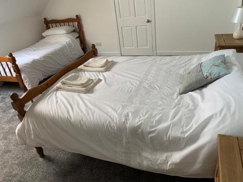 a bedroom with two beds with white sheets and towels at 18 Cross Skigesrta Road in Swanibost