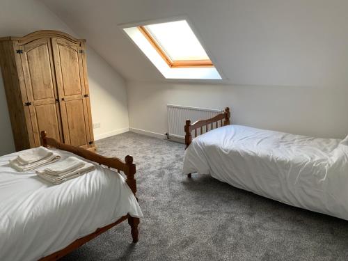 a attic bedroom with two beds and a skylight at 18 Cross Skigesrta Road in Swanibost