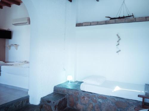 a bedroom with a bed and a light on the wall at Mar-Nik Village in Paliochori