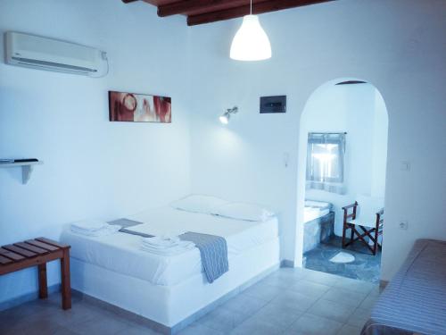 a white room with two beds and a mirror at Mar-Nik Village in Paliochori
