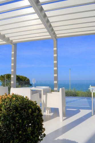 a patio with a white pergola and a table at La Chiave dei Trabocchi in San Vito Chietino