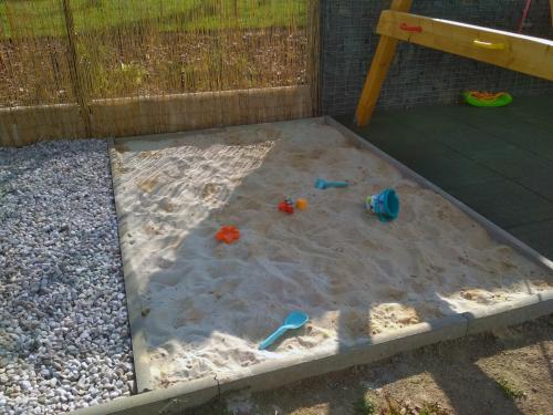 a sandbox with sand and toys in the sand at Domeček u Prahy in Nupaky