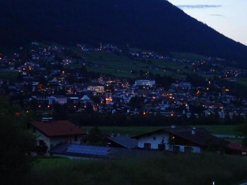 a view of a city at night with a mountain at Chalet Stubai inklusive Stubai Super Card in Fulpmes