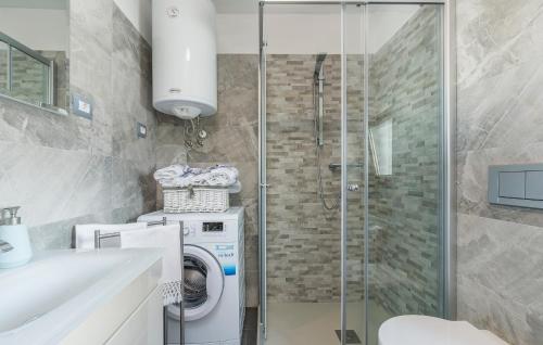 ein Badezimmer mit Waschmaschine und Dusche in der Unterkunft Apartment ire' in Karšete