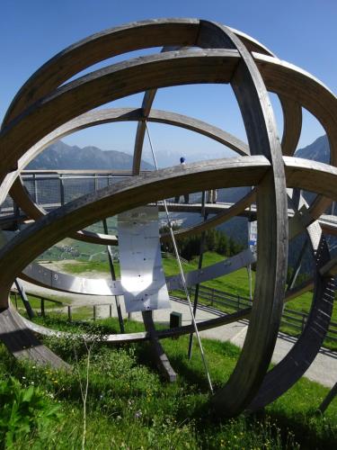 a large wooden wheel sitting in the grass at Chalet Stubai inklusive Stubai Super Card in Fulpmes