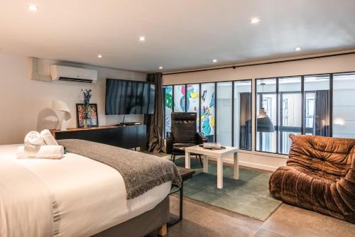 une chambre d'hôtel avec un lit et une chaise dans l'établissement Outstanding Artist Loft - Between Marais and Canal, à Paris
