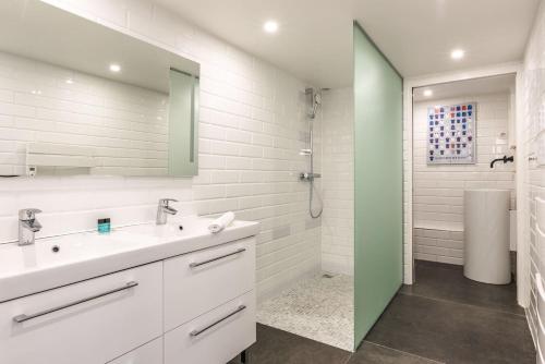 une salle de bain blanche avec un lavabo et une douche dans l'établissement Outstanding Artist Loft - Between Marais and Canal, à Paris