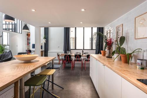 une cuisine avec des comptoirs en bois et une salle à manger dans l'établissement Outstanding Artist Loft - Between Marais and Canal, à Paris
