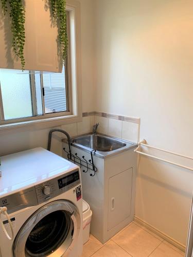 a laundry room with a sink and a washing machine at Pinnacle Views in Halls Gap