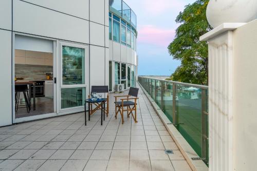 a balcony with chairs and tables on a building at Kingsview CBD Tauranga in Tauranga