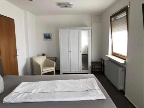 a bedroom with a bed and a chair and a window at Gasthof ´s Gräbele in Tübingen
